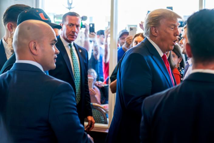 Former President Donald Trump&#39;s valet Walt Nauta, left, watches as Trump greets supporters at Versailles restaurant with Trump on Tuesday, June 13, 2023, in Miami. Nauta, a personal aide whom prosecutors say moved boxes from a storage room to Trump&#39;s residence for him to review and later lied to investigators about the movement, joined Trump on Tuesday in federal court.
