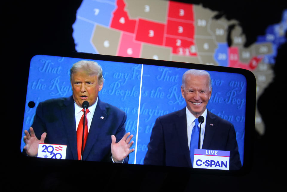 A split screen showing images of Donald Trump and Joe Biden on a smartphone during a presidential debate in Nashville in 2020.